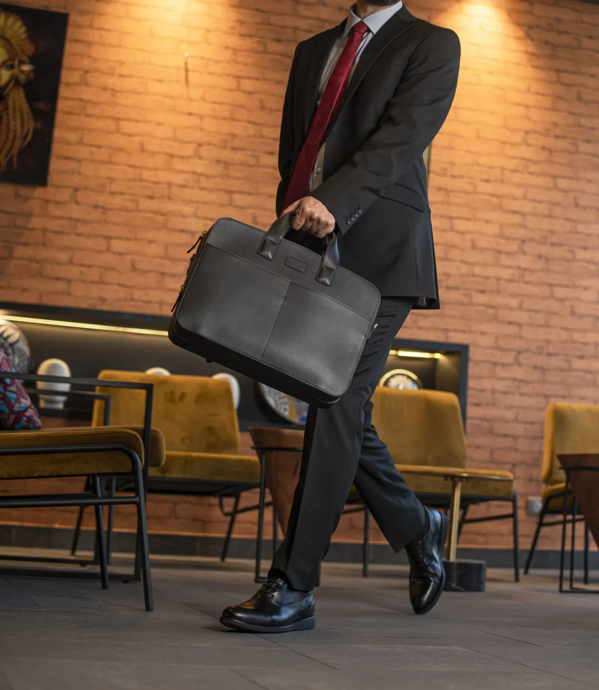 Anik Business noir, porté à la main dans un salon d'hôtel