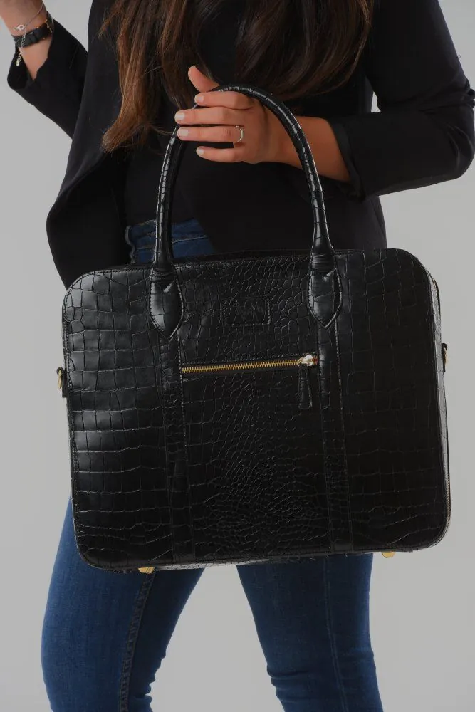 Sac croco noir porté à l'épaule
